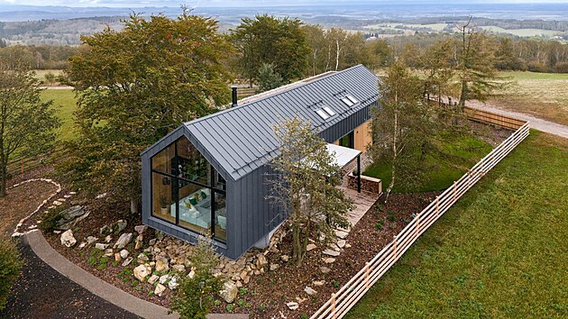 Nejkrásnější dům: protáhlá silueta domu kopíruje linii buků uprostřed pozemku, končí u terénního zlomu a otevírá se proskleným štítem do krajiny.