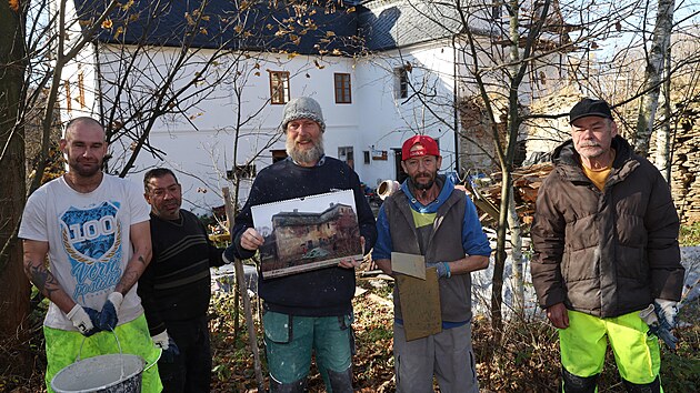 Muži z azylového domu Armády spásy v Krnově dobrovolně pomáhají s opravami staré rychty v Karlovicích. Ivo Dokoupil z Hnutí Duha Jeseníky (uprostřed) na snímku ukazuje, jak rychta vypadala před obnovou.