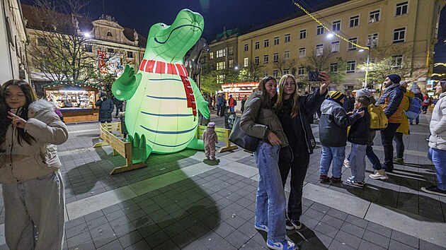 Nafukovací drak sedí u sochy Jošta na Moravském náměstí v Brně. (listopad 2025)