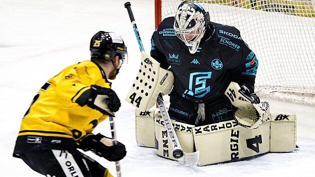 Brankář Karlových Varů Dominik Frodl vyráží teč Davida Kašeho z Litvínova.