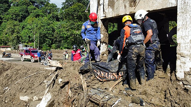Záchranáři na indonéském ostrově Sumatra vytahují z trosek oběť záplav. (1. prosince 2025)
