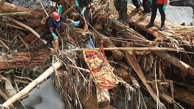 Záchranáři na indonéském ostrově Sumatra vytahují z trosek oběť záplav. (1. prosince 2025)