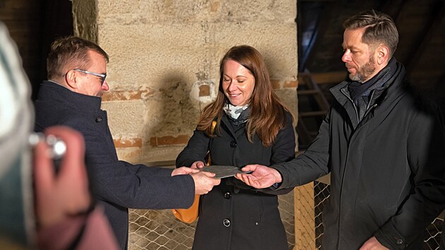 Biskup Tomáš Holub předává symbolickou šablonu břidlice zástupcům stavební firmy. (8. ledna 2026)