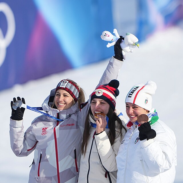 Snowboardistka Zuzana Maděrová (uprostřed) se zakusuje do zlaté medaile.