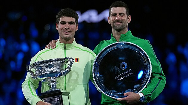 Carlos Alcaraz (vlevo) a Novak Djokovič pózují s trofejemi po finále Australian Open.