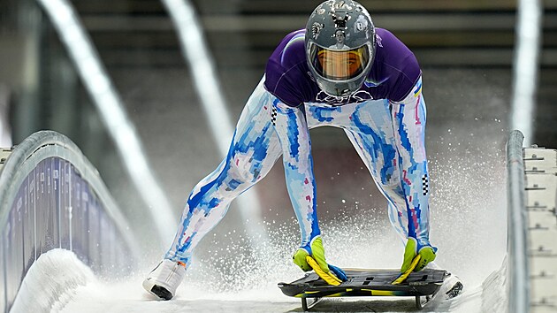 Ukrajinský skeletonista Vladyslav Heraskevyč na olympijské dráze v Cortině d’Ampezzo v helmě, na níž jsou fotografie lidí zabitých během války na Ukrajině. (9. února 2026)