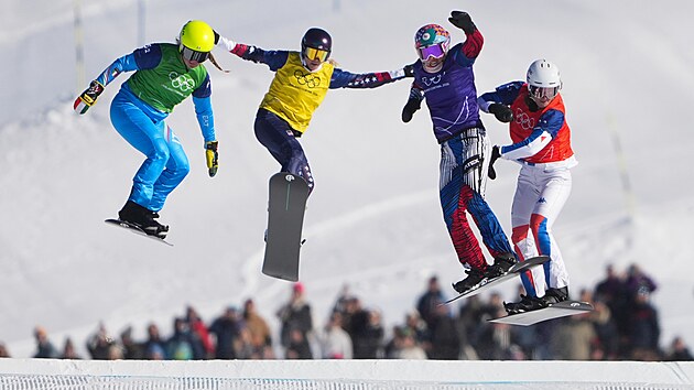 Eva Adamczyková (fialový dres) z České republiky v akci během čtvrtfinále smíšených týmů ve snowboardcrossu. (15. února 2026)