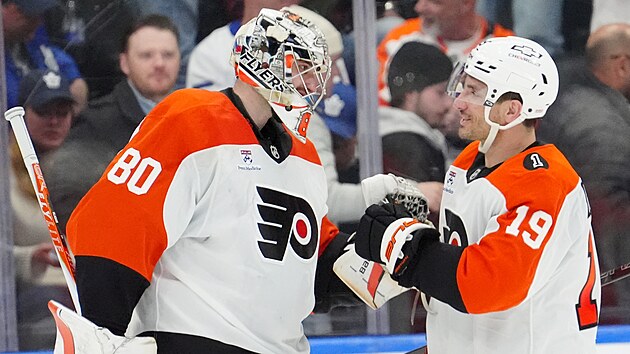 Dan Vladař z Philadelphia Flyers přijímá gratulace od spoluhráče Garneta Hathawaye po výhře nad Toronto Maple Leafs.