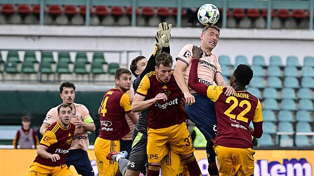 Pardubick&yacute; obr&aacute;nce Simon Bammens hlavičkuje m&iacute;č před brank&aacute;řem Hugem Janem...