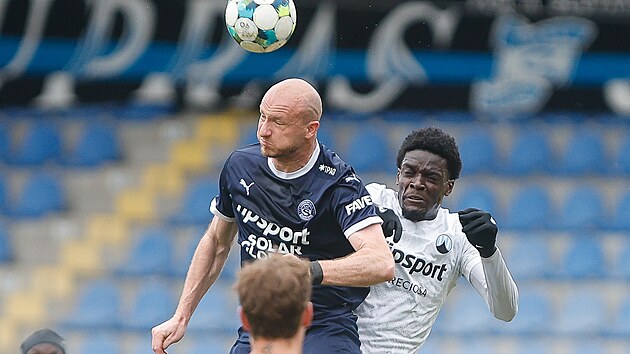&Uacute;točn&iacute;k Michael Krmenč&iacute;k ze Slov&aacute;cka hlavičkuje v souboji s libereck&yacute;m Angem N&rsquo;Guessanem.