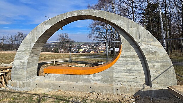 Budi&scaron;ovsk&aacute; lavička Pod Ml&eacute;čnou dr&aacute;hou m&aacute; hotov&yacute; betonov&yacute; skelet. Zač&iacute;n&aacute; se s břidlicov&yacute;m obkladem.