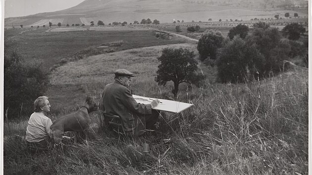 Emil Filla s manželkou a boxerkou Evičkou kreslí v plenéru Českého středohoří na fotografii Josefa Sudka.