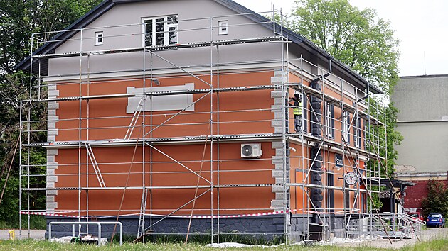 Místní budově kvůli agresivnímu nátěru neřekli jinak než „pomeranč“ nebo „pouťová atrakce“. Nyní už ale dělníci křiklavou omítku přetírají. (22. května 2026)