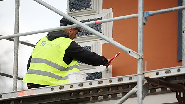 Křiklavá budova pacovského nádraží už dostává o něco tmavší fasádu. (22. května 2026)