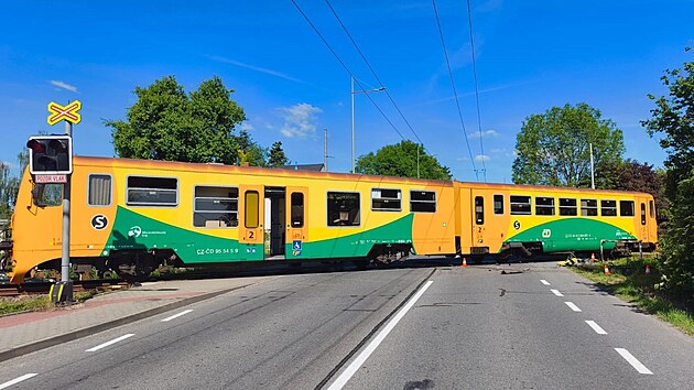 Osobní vlak na železničním přejezdu v Krnovské ulici v Opavě chvíli poté, co narazil do převráceného automobilu. (29. května 2026)