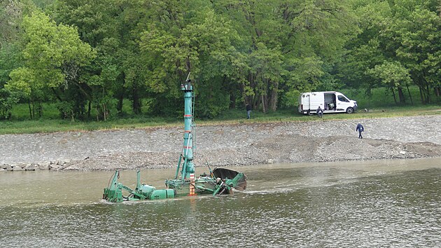 Zat&iacute;mco obsluha s d&aacute;lkov&yacute;m ovl&aacute;d&aacute;n&iacute;m sed&iacute; na břehu, buldozer cestuje po dně Labe a vyv&aacute;ž&iacute; materi&aacute;l na kraj ř&iacute;čn&iacute;ho koryta.