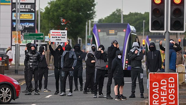 Dav demonstrantů se shromažďuje na silnici po útoku nožem v severoirském Belfastu. (9. června 2026)