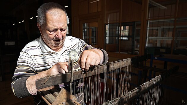 Rudolf Klimenko natahuje nitě do tkalcovského stavu.
