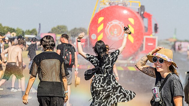 Fanoušci na královéhradeckém letišti se snaží ochladit vodou od hasičů během tropického vedra na hudebním festivalu Bludfest. (27. června 2026)
