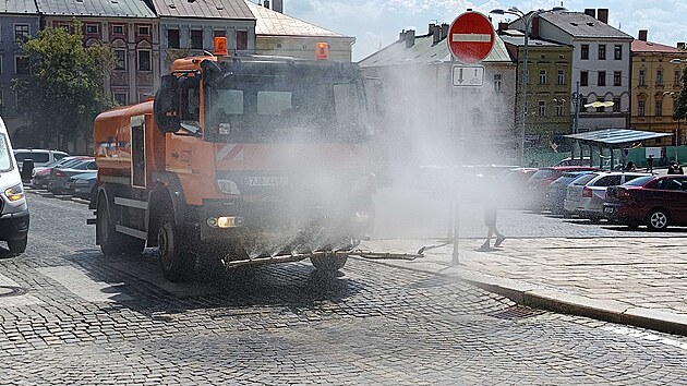Cisterna Služeb města Jihlavy (SMJ) ochlazuje rozpálené dlažební kostky na Masarykově náměstí. Jemná mlha z trysek ulevuje od tropického vedra, které v posledních dnech Vysočinu sužuje. (24. června 2026)