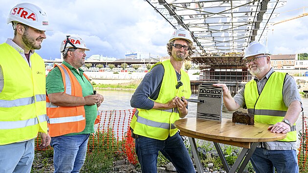 Oblastní muzeum v Ústí nad Labem pokřtilo pod rekonstruovaným mostem Dr. Edvarda Beneše nýtovačkou knihu Mosty – Brücken. Zleva konzervátor Jakub Doležel, stavbyvedoucí Jan Ekrt, historik Martin Krsek a ředitel muzea Václav Houfek. (27. července 2026)