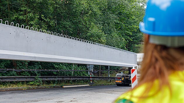 Stavbaři pomocí jeřábu osazují osm železobetonových nosníků. Každý z nich váží 28,5 tuny a měří téměř 30 metrů.