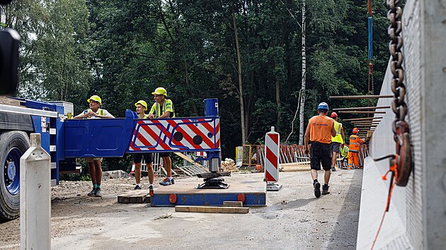 Stavbaři pomocí jeřábu osazují osm železobetonových nosníků. Každý z nich váží 28,5 tuny a měří téměř 30 metrů.