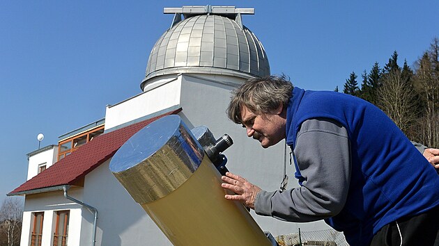 Jaroslav Jašek pozoruje částečné zatmění Slunce před svou observatoří v Jedlové. (20. března 2015)