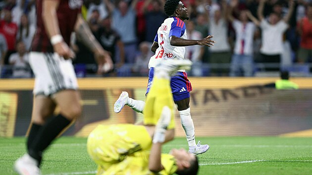 Ernest Nuamah se raduje, ghanský útočník právě poslal Lyon do vedení proti Spartě v odvetě 3. předkola Ligy mistrů, na zemi zpytuje svědomí brankář Jakub Surovčík, který mu svým zaváháním branku vstřelit umožnil.