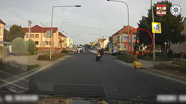Při ujíždění motorkář objel kolonu vozidel stojících na červenou před stavbou a semafor projel.