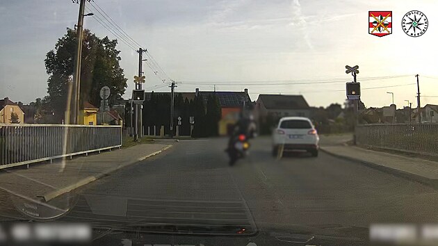 Ujíždějící motorkář předjížděl na železničním přejezdu.