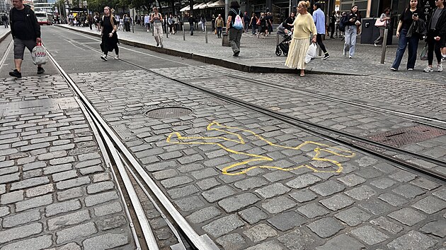Neskákej mi pod kola. Kampaň dopravního podniku symbolizuje silueta nastříkaná do kolejiště tramvají. V tomto případě na Andělu. (září 2026)