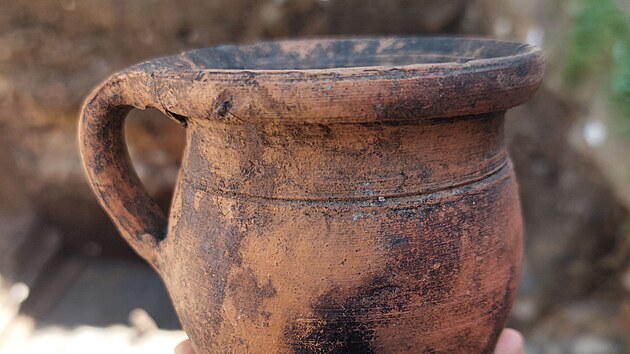 Při demolici bývalého obchodního domu Slezanka v centru Opavy archeologové pod povrchem Horního náměstí odkryli zachovalé zděné sklepy z 15. až 16. století i starší středověké vrstvy. Tým pod vedením Barbary Marethové narazil i na měšťanský dům, který lehl popelem na přelomu 13. a 14. století. Nálezy podrobně zdokumentovali pomocí 3D skenerů i dronů. Na snímku je hrnek ze 17. století. (září 2026)