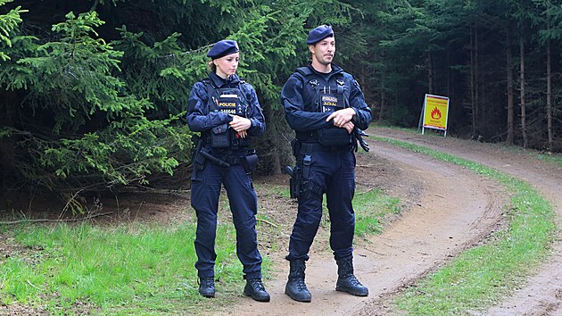 Policisté hlídkují na přístupové cestě ke kontaminované lokalitě v bývalém vojenském prostoru. (16. září 2026)