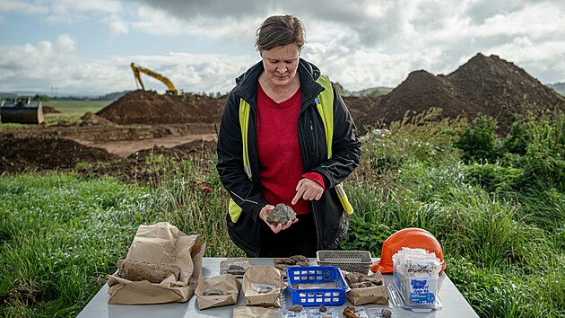 Archeoložka z Archeologického centra Olomouc Michaela Bartoš Dvořáková ukazuje artefakty nalezené při archeologickém záchranném výzkumu na budoucím úseku D35 Úlibice-obchvat. (25. září 2026)