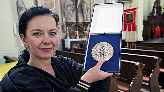 Na snímku starostka Města Touškova Kateřina Duchková. Ukazuje stříbrnou medaili, která ležela pod baronovým tělem. Po vyčištění se ukázalo, že jde o vzácnost ze 16. století. (2. října 2026)