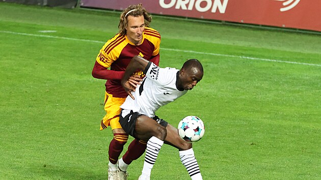 Karvinsk&yacute; z&aacute;ložn&iacute;k Ousmane Conde si hl&iacute;d&aacute; balon před Matějem Hanouskem z Dukly Praha.