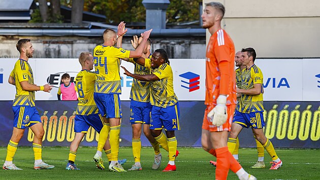 Zl&iacute;n&scaron;t&iacute; fotbalist&eacute; se raduj&iacute; z g&oacute;lu před olomouck&yacute;m brank&aacute;řem Janem Koutn&yacute;m.