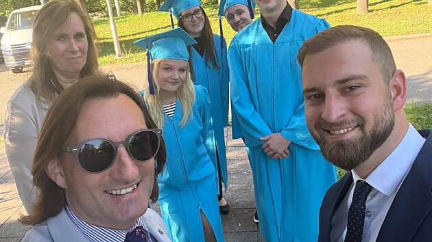 Poslanec ANO Denis Doksansk&yacute; (vlevo) a jeho syn Samuel s absolventy Sion High School.