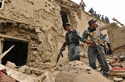 Afghántí policisté ped domem, v nm se skrývali talibanci a který byl vyhozen do povtí.