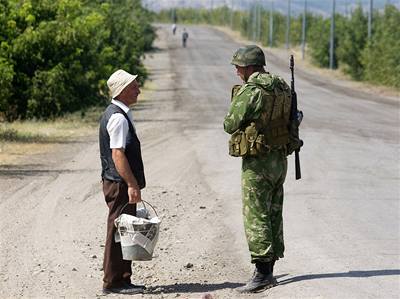 Gruzínský civilista mluví s ruským vojákem na silnici u msta Gori. 