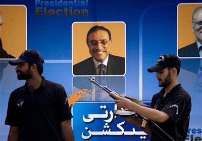 Pákistánské bezpenostní síly u plakát prezidentských kandidát, uprosted je Ásif Alí Zardárí. 