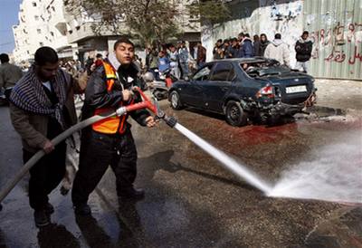 Palestinci umývají v pásmu Gazy krev z ulice po mrtvých Palestincích, které zabila izraelská raketa.