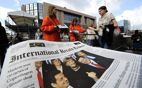Kameloti rozdávají fiktivní vydání International Herald Tribune.
