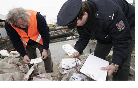 Pavel Wind z beclavské elezniní stanice (vlevo) a policista prohlíejí dopisy, které 14. bezna dlníci nalezli v takzvaném potovním tunelu na elezniním nádraí v Beclavi.