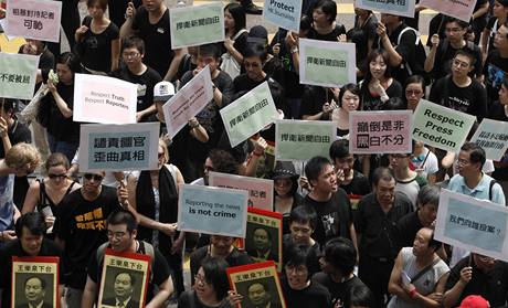 Asi sedm stovek noviná obleených v erném poádalo protestní prvod proti zásahu policie proti tem hongkongským novinám v provincii Sin-iang.