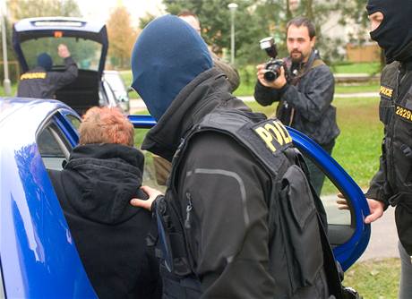 Policisté z Útvaru pro odhalování organizovaného zloinu (ÚOOZ) odvádjí mue z panelového domu na sídliti Vltava v eských Budjovicích.