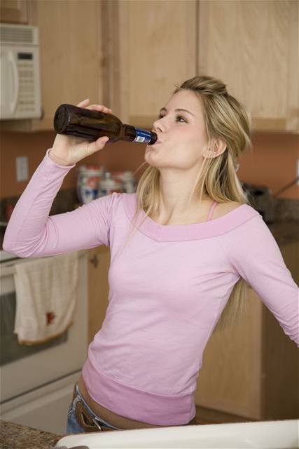 Mladá dívka popíjí alkohol.