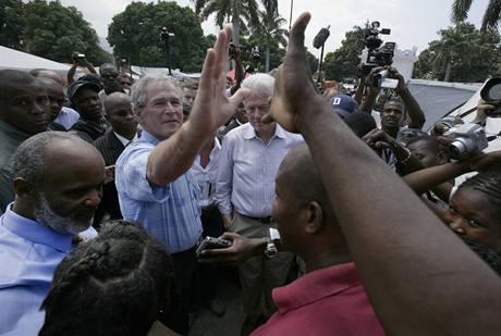 George Bush si podává ruku s Haiany.