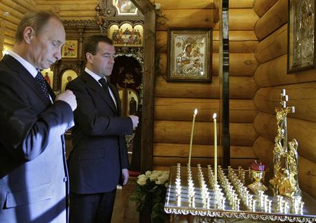 Ruský prezident Dmitrij Medvedv a premiér Vladimir Putin zapalují svíky za zemelé na palub polského vládního letounu v kapli u prezidentského sídla v Moskv